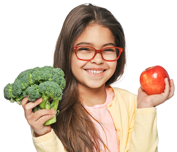 young girl smiling while holding vegetables