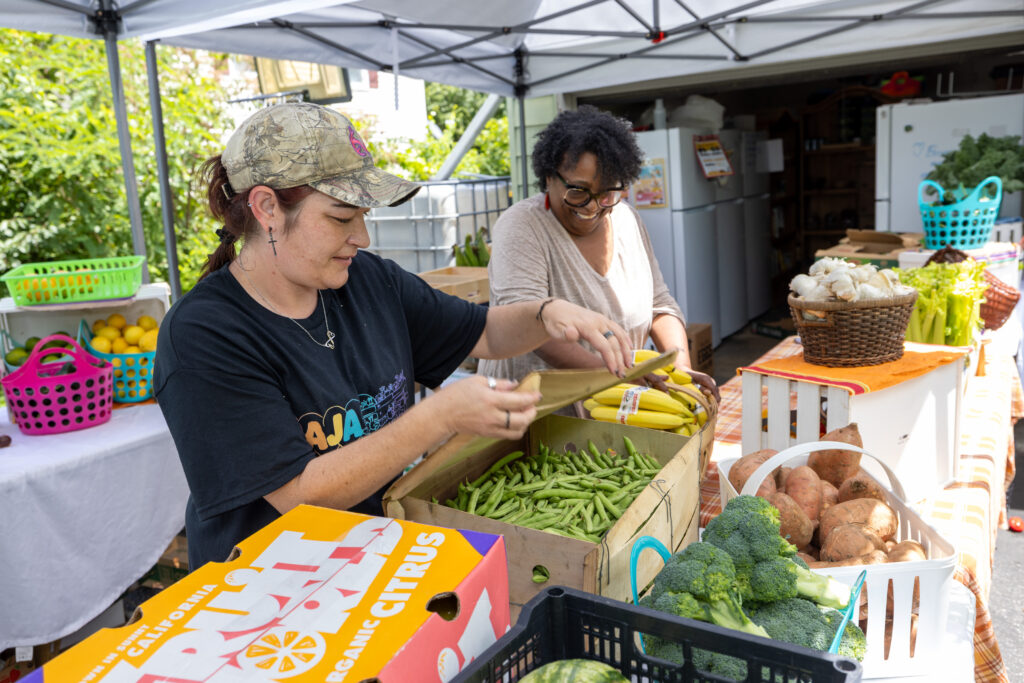two women picking out vegetables