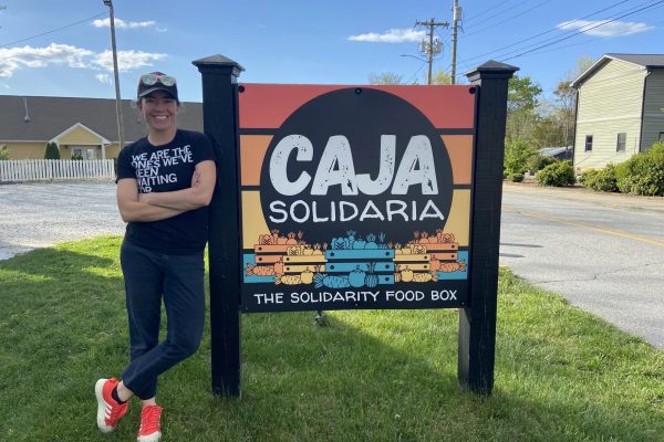 Cata Norena posing by the Caja Solidaria sign